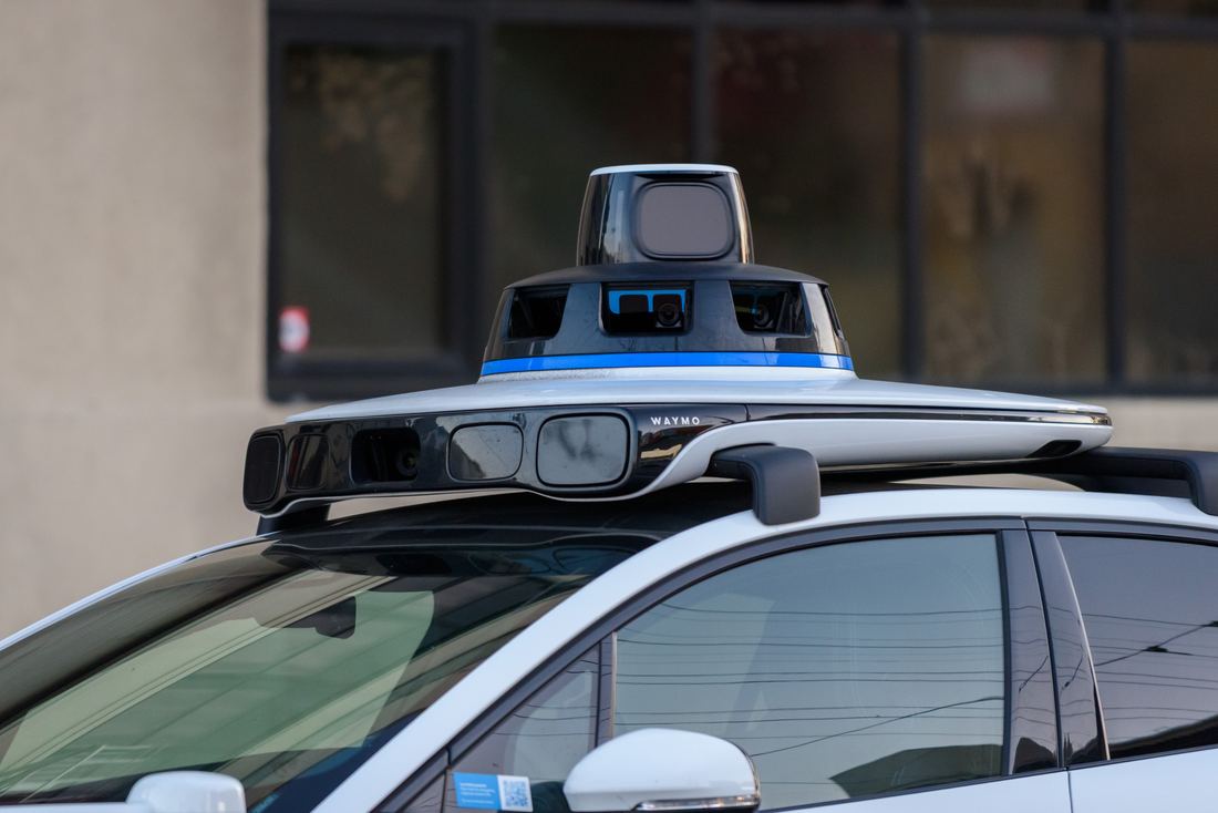 Close-up of the spinning lidar and camera dome on a robotaxi roof