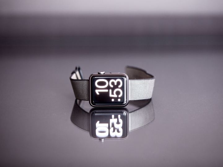 A smartwatch with a dark band lying on its side on a table